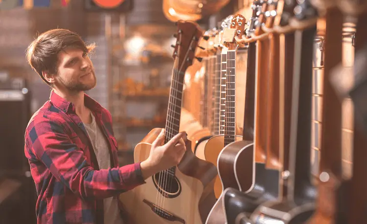 young man choose his first guitar