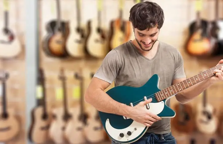 young man play on electric guitar